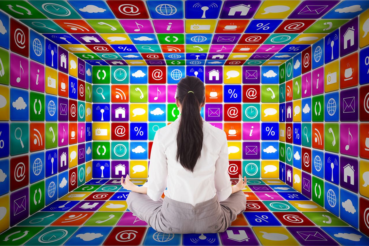 Woman sitting cross-legged in front of a wall of glowing app icons